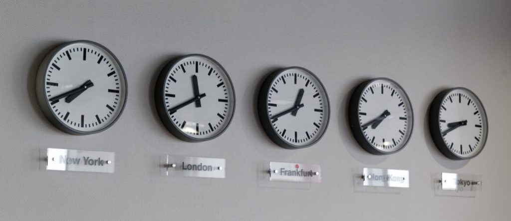 an image of five clocks on a wall